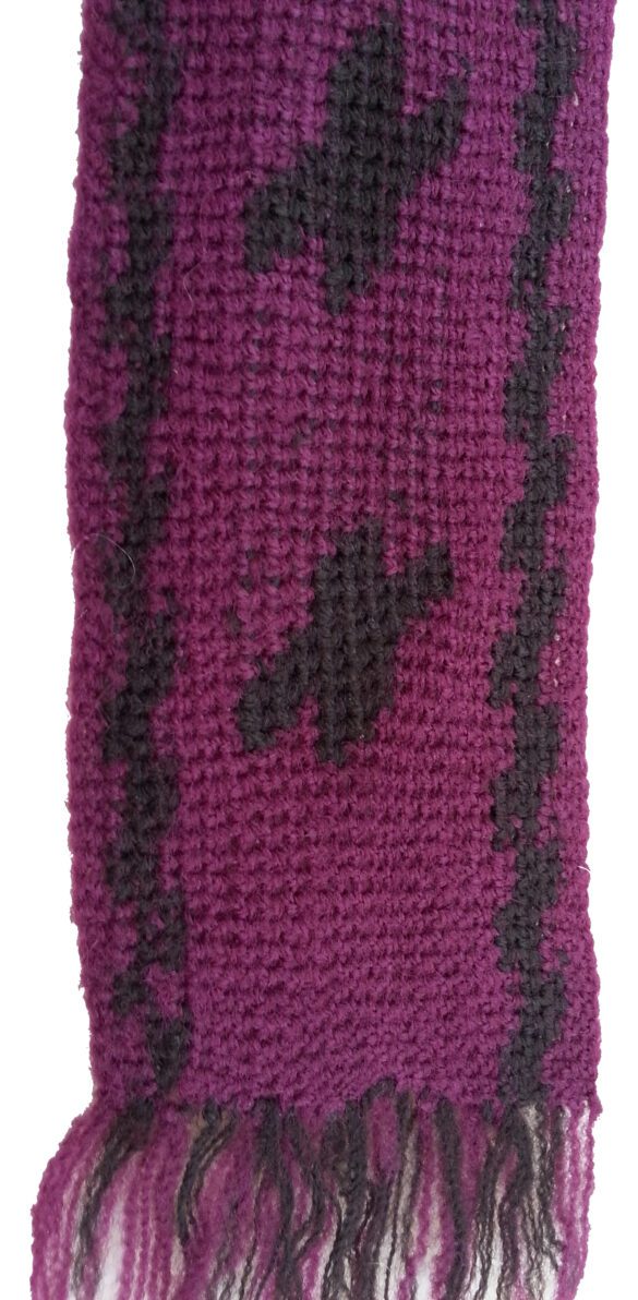 Närbild virkat förklädesband i cerise och brunt